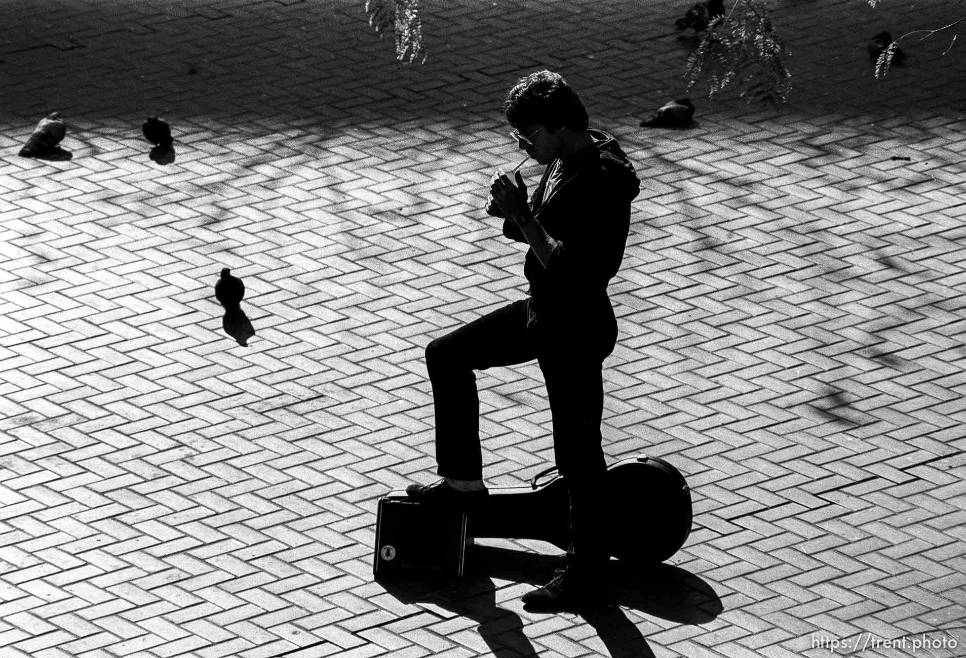 Street musician lights a cigarette at 5th and Market St.