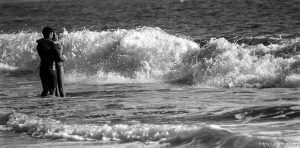 Couple embracing in waves.