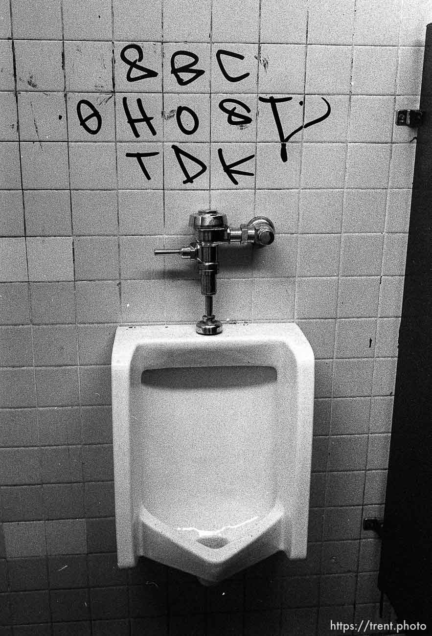 Graffiti over a urinal.