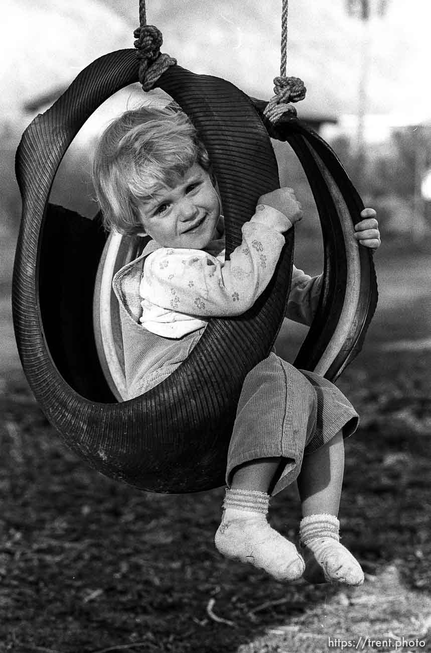 Little girl in tire swing.