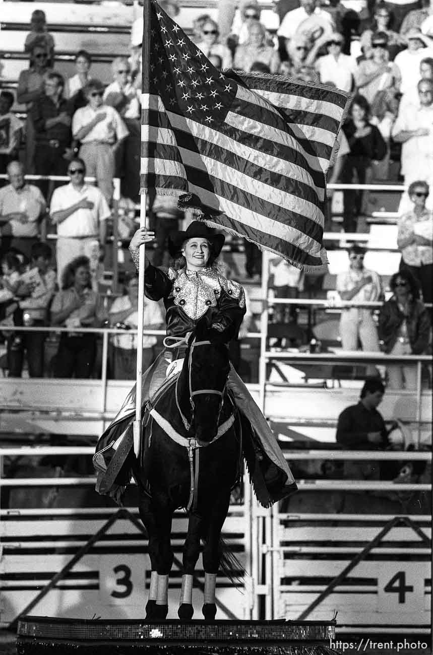 Girl on horse with American flag at Ute Stampede rodeo.