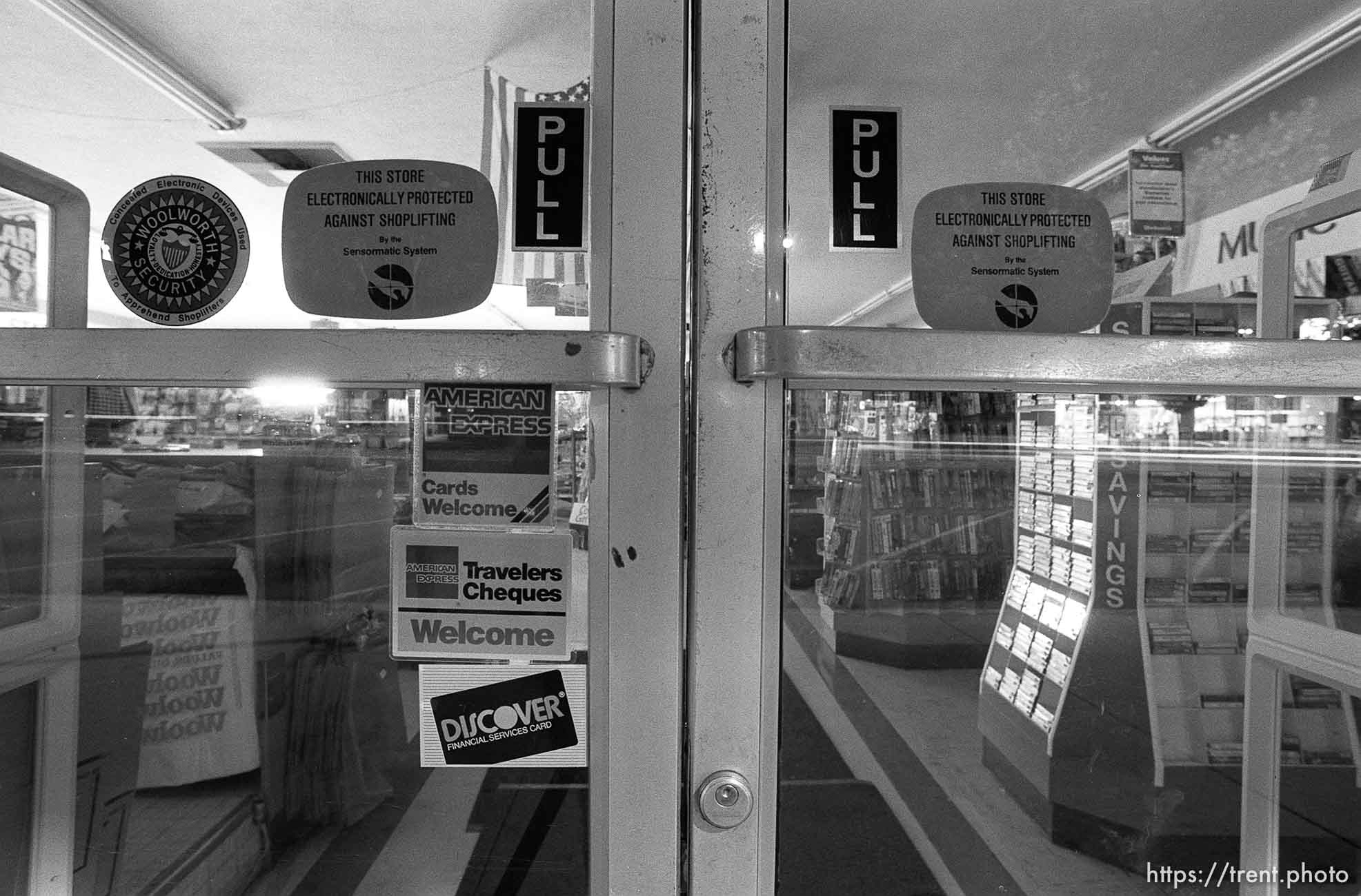 Store glass doors and stickers on Center Street at night.