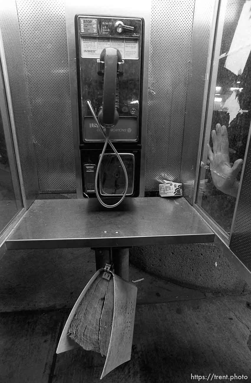 Pay phone and Trent's hand on Center Street at night.