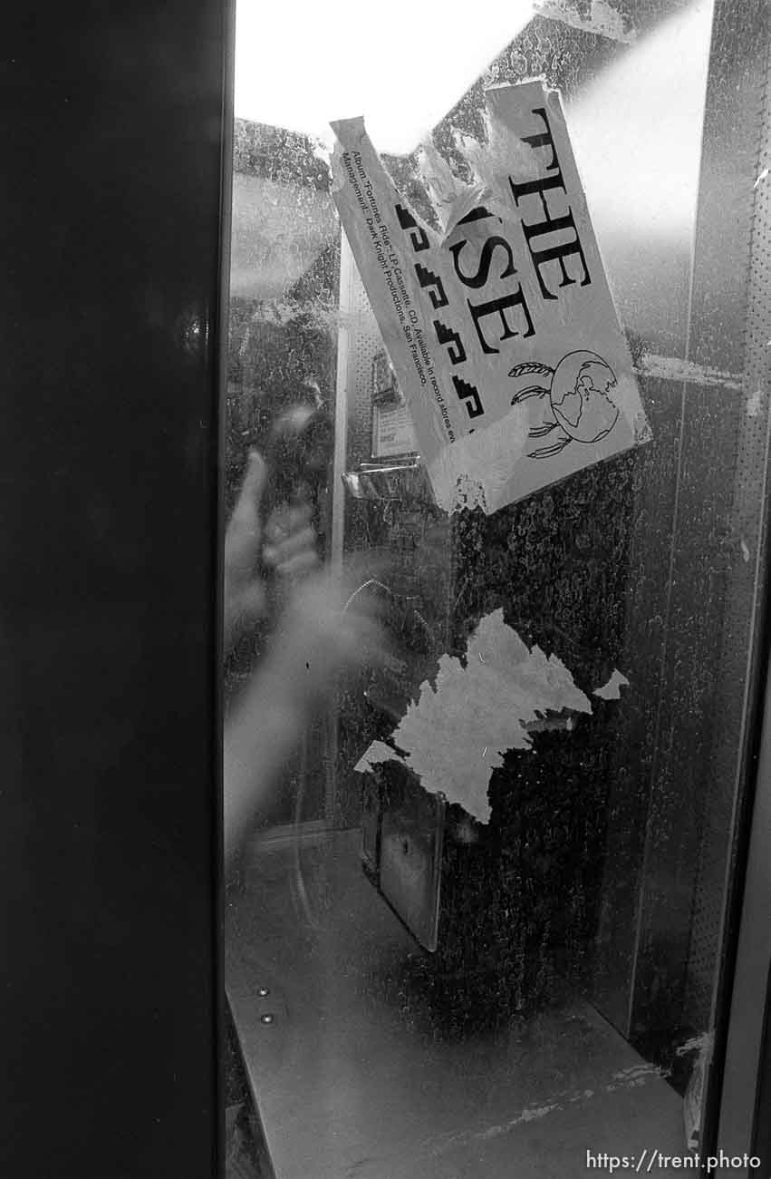 Trent dialing payphone on Center Street at night.