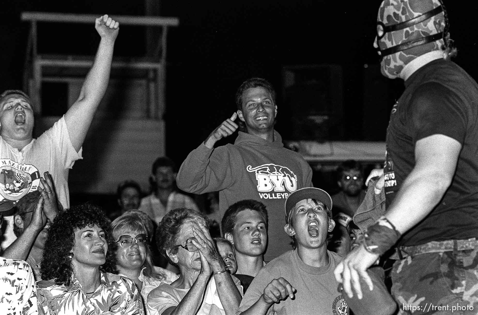 Heel wrestler is cheered and jeered by crowd at professional wrestling match.