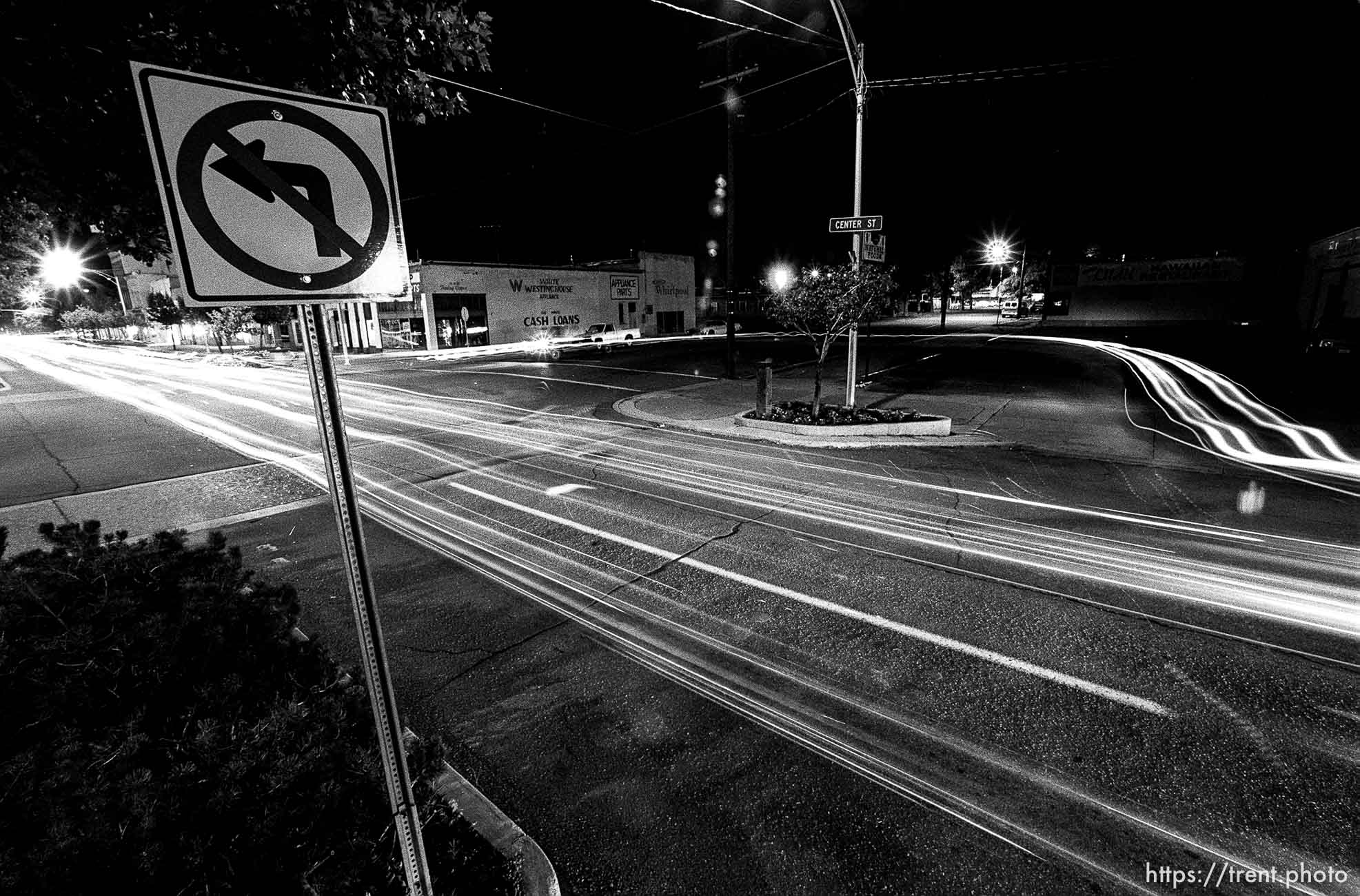 Cars U-turn to cruise on Center Street at night.