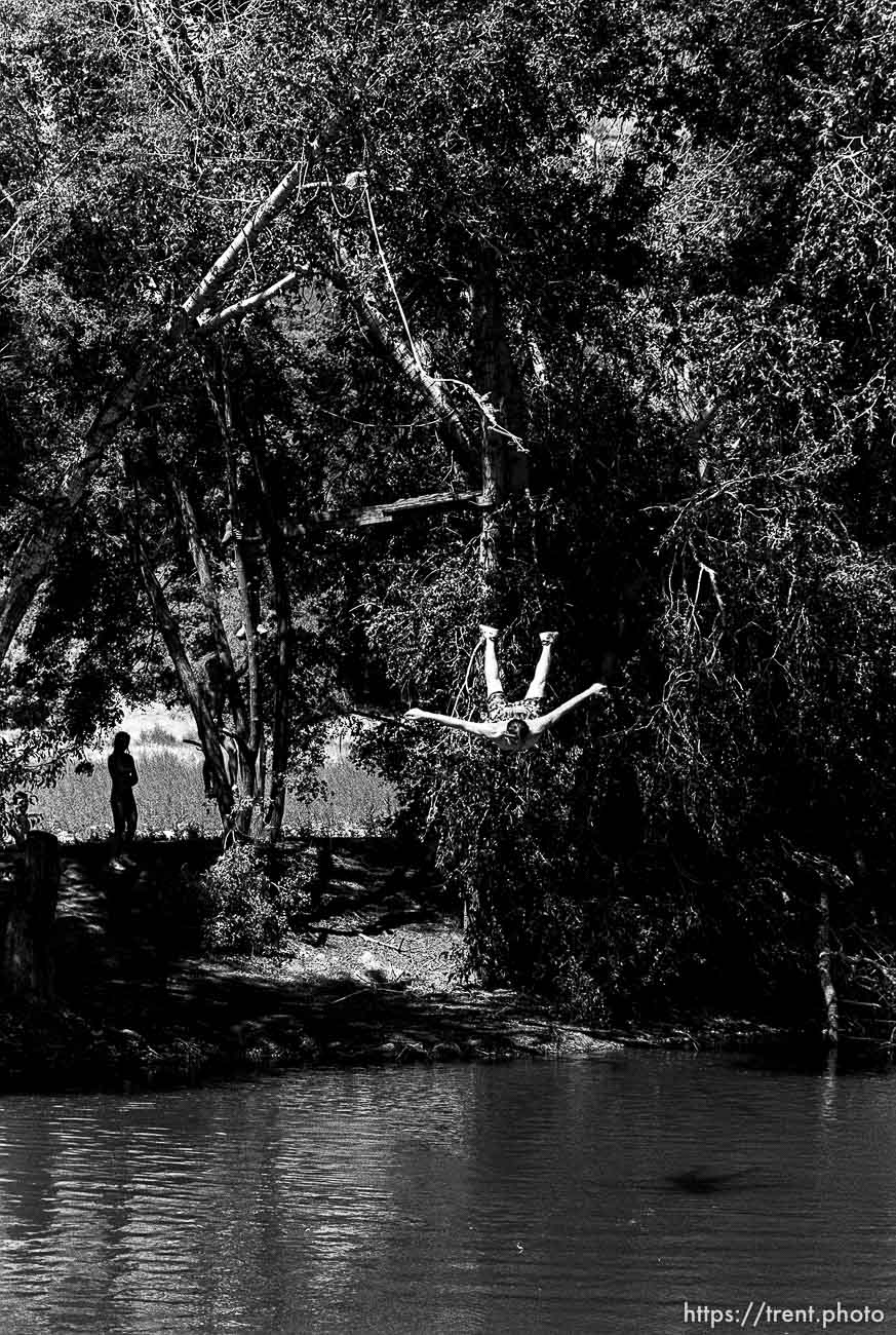 Guy jumping off a rope swing at diversion dam.