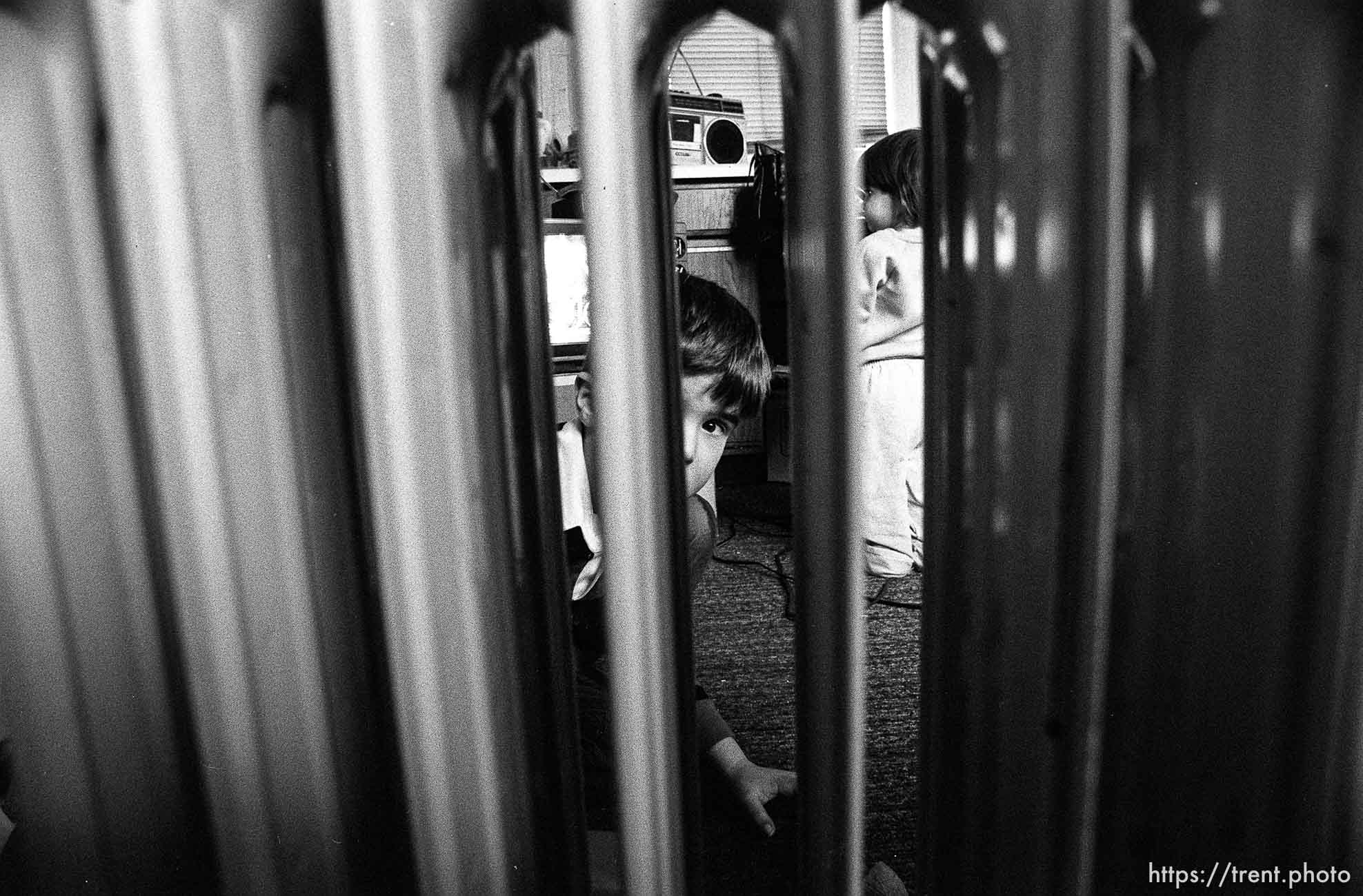 People living in the Hideaway Motel. Boy looking through space heater.