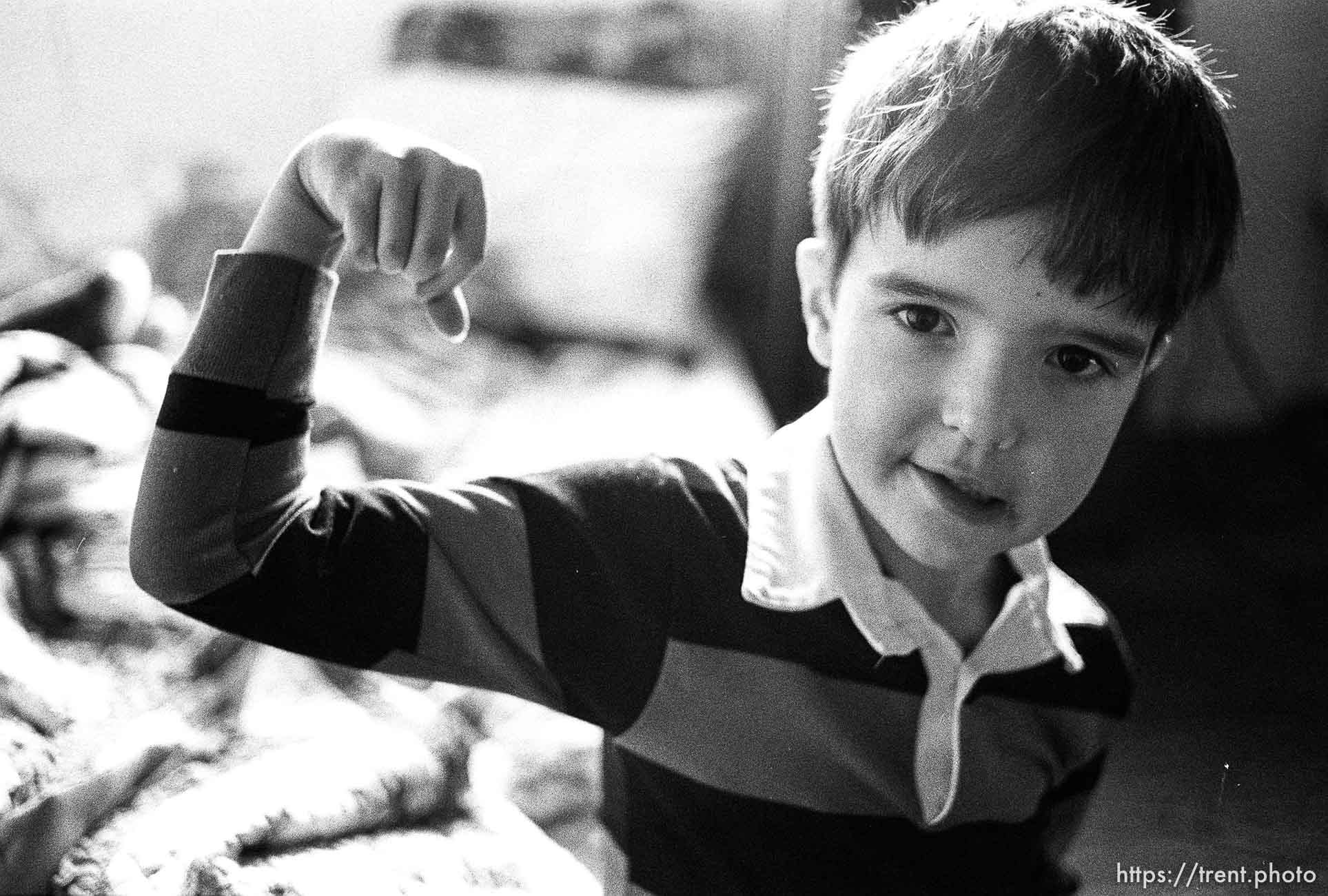 People living in the Hideaway Motel. Boy shows his muscles.