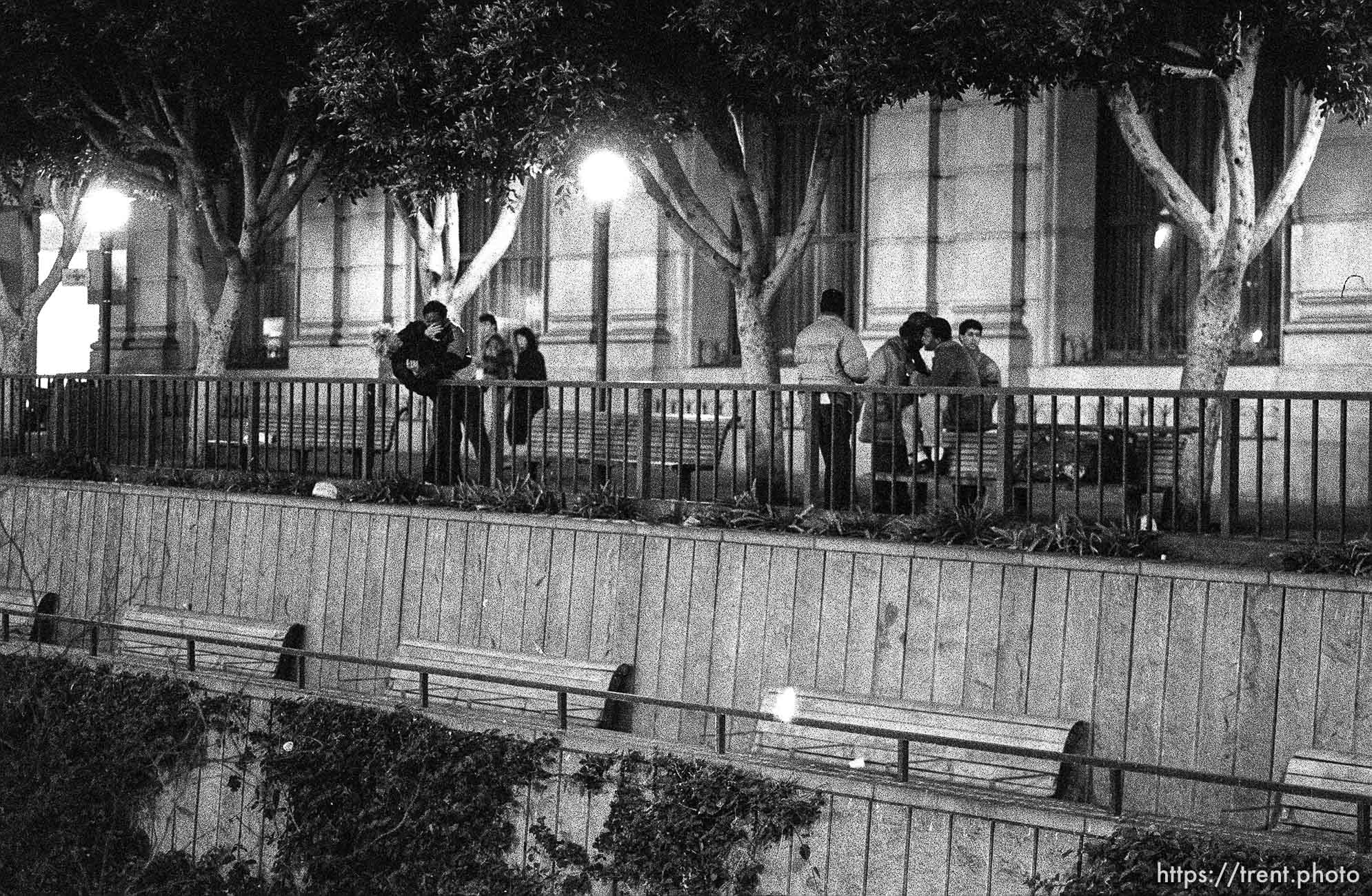 Man nearly throwing another man over a railing on Market Street at night.