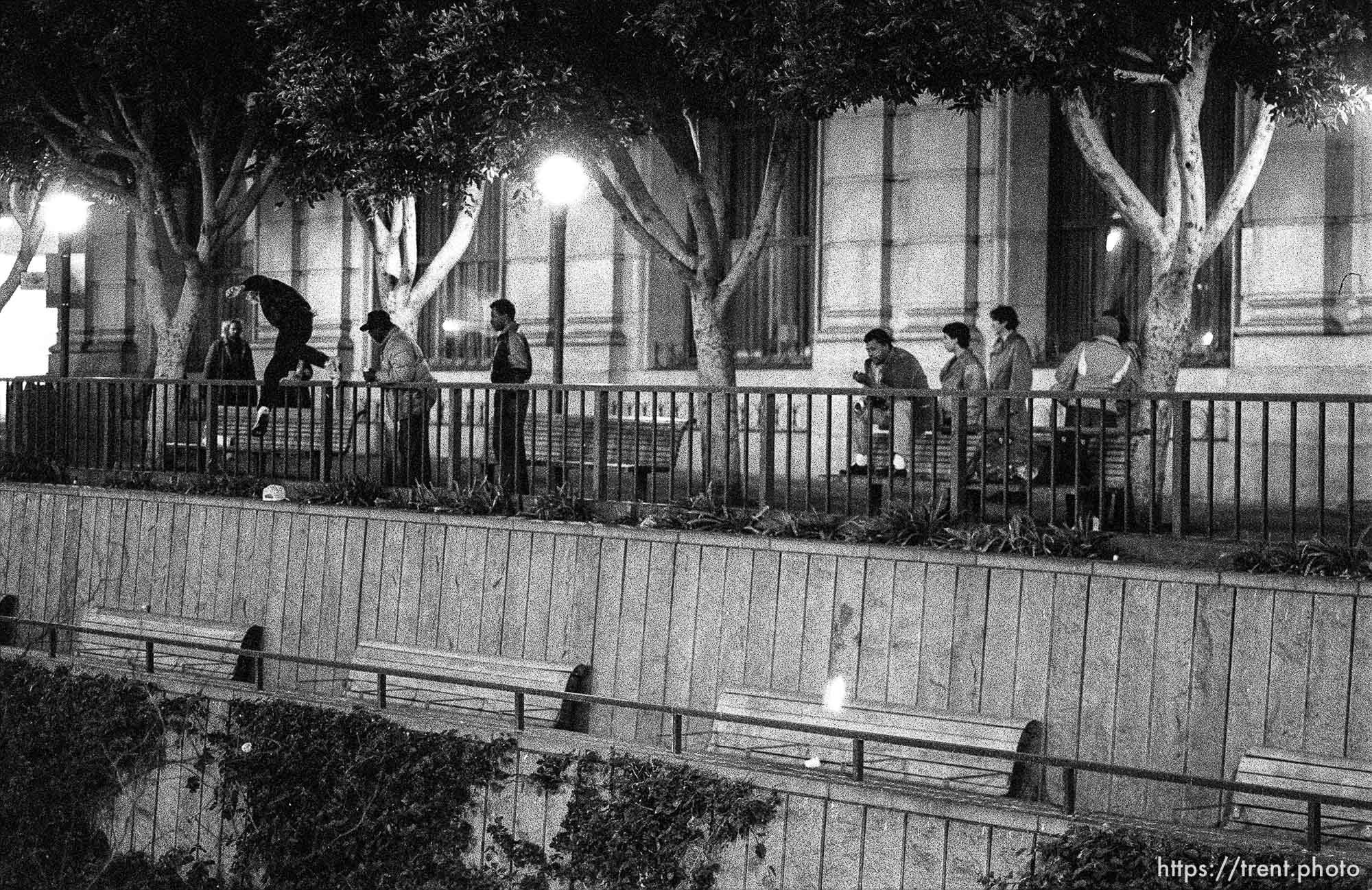 Man jumping over railing after being nearly thrown over it on Market Street at night.