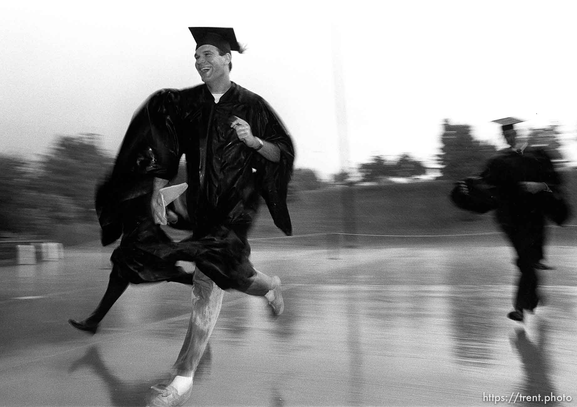 BYU graduates running to their graduation in the pouring rain.