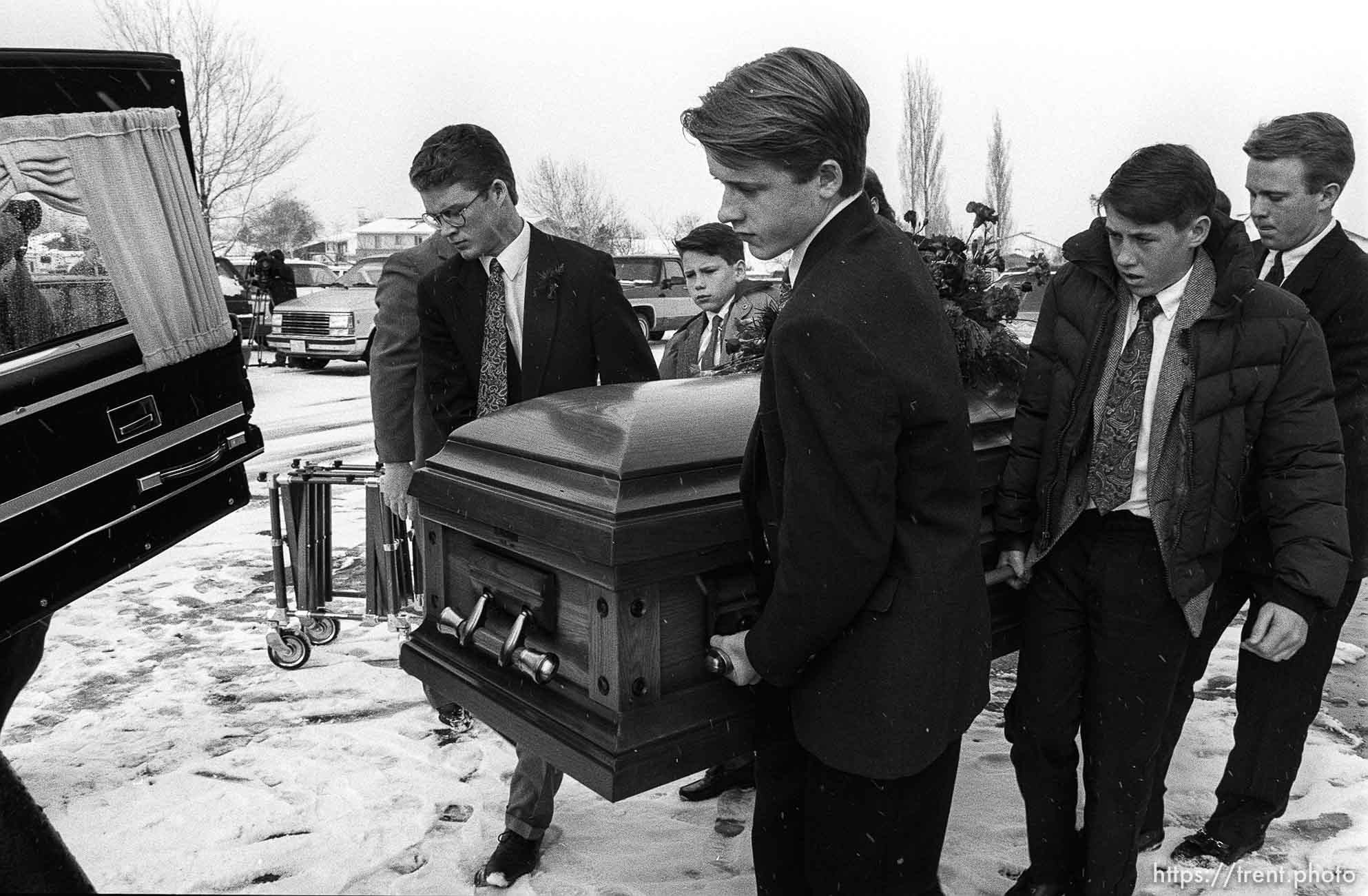 Family carrying casket at funeral of School superintendant (Moss).