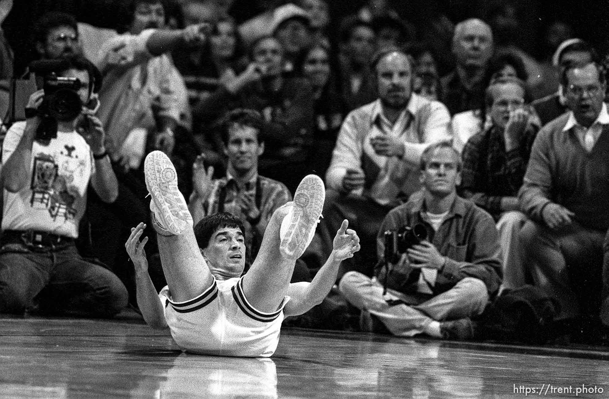 John Stockton laying on his back at Jazz vs. Detroit Pistons. In background (directly behind) Ravell Call and at right Bryan Anderton.