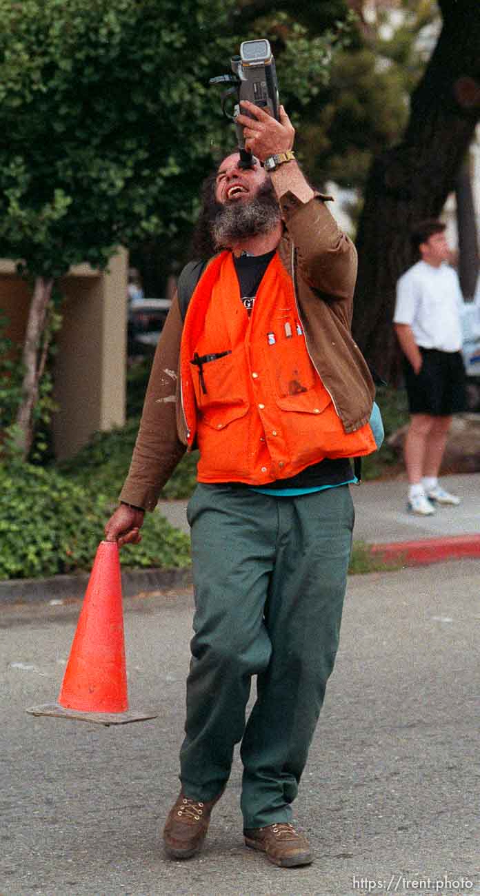 Strange protester with traffic cone and camcorder during riots and protests.