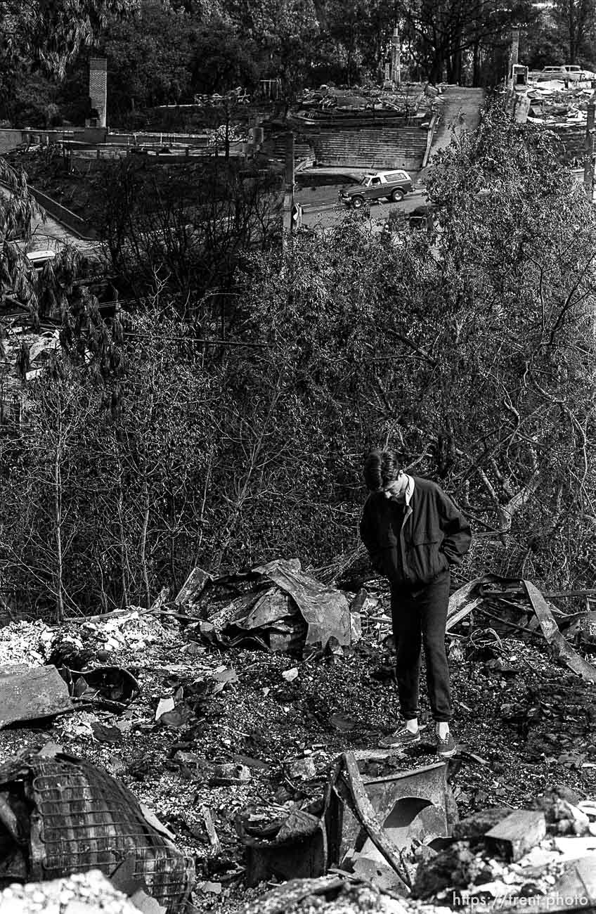 Man standing in the remains of his family's home after the Oakland Hills Fire.