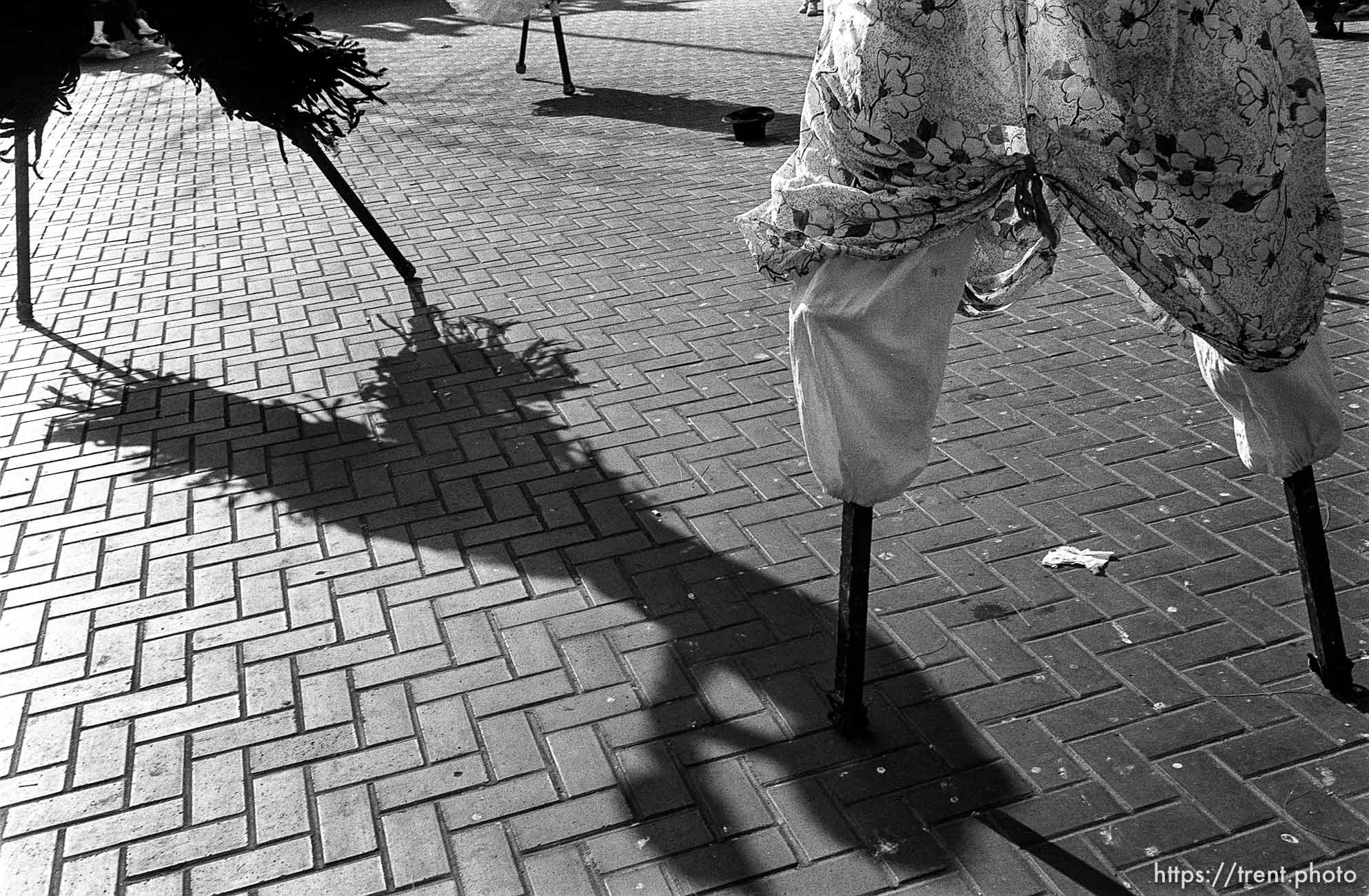 People on stilts (their feet and shadows)