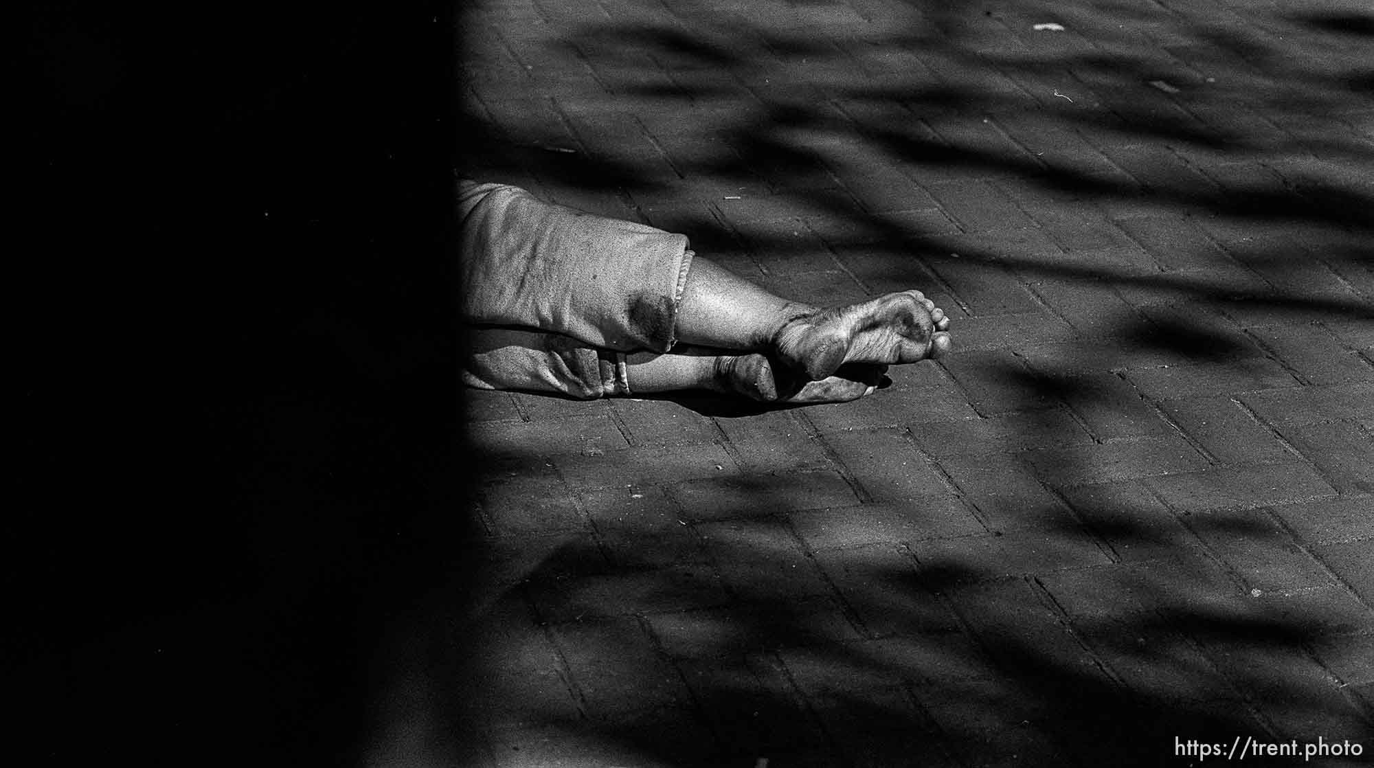 Woman sleeping on sidewalk (her feet)