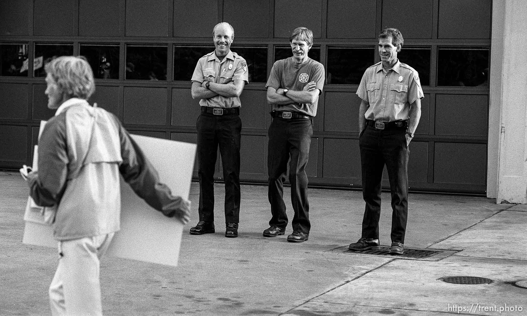 Orinda Firefighters laugh at protesters during protests over President George Bush's visit to town.