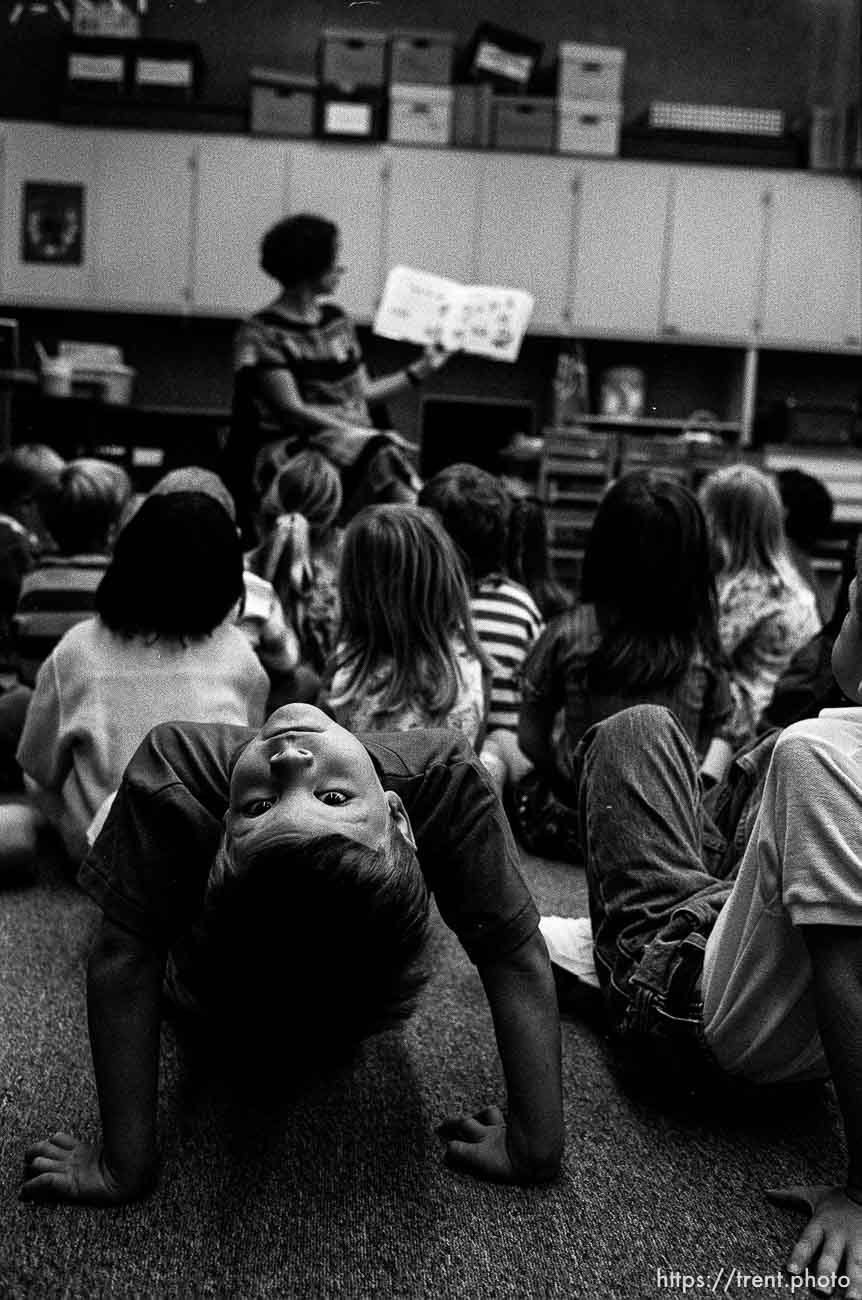 Kid looking over backward at me during reading time at first day of kindergarten