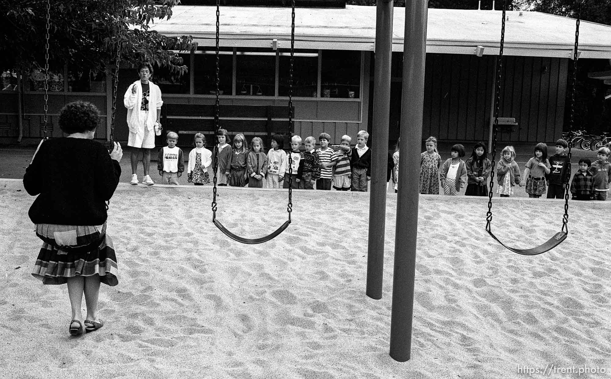 Teacher shows kids the proper way to swing at first day of kindergarten