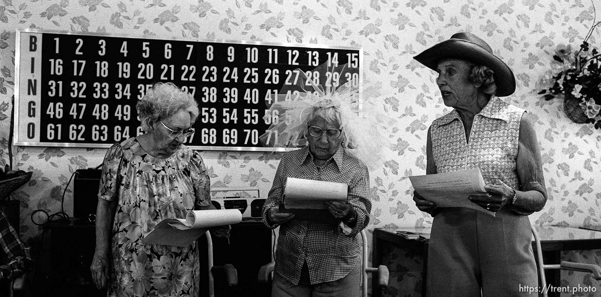 Old women in front of BINGO board at play rehearsal at a senior home