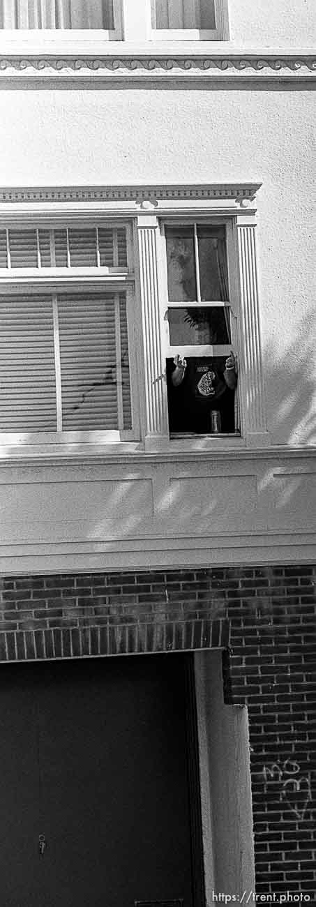 Man in window flips off American Indian Movement people at anti-Christopher Columbus protest.