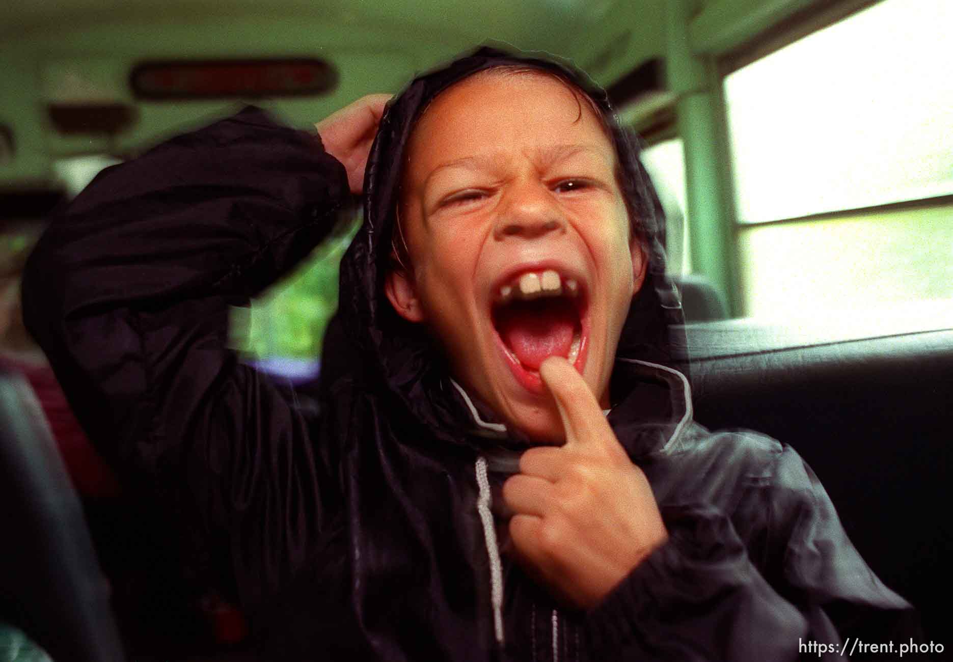 Kid making a face on school bus.