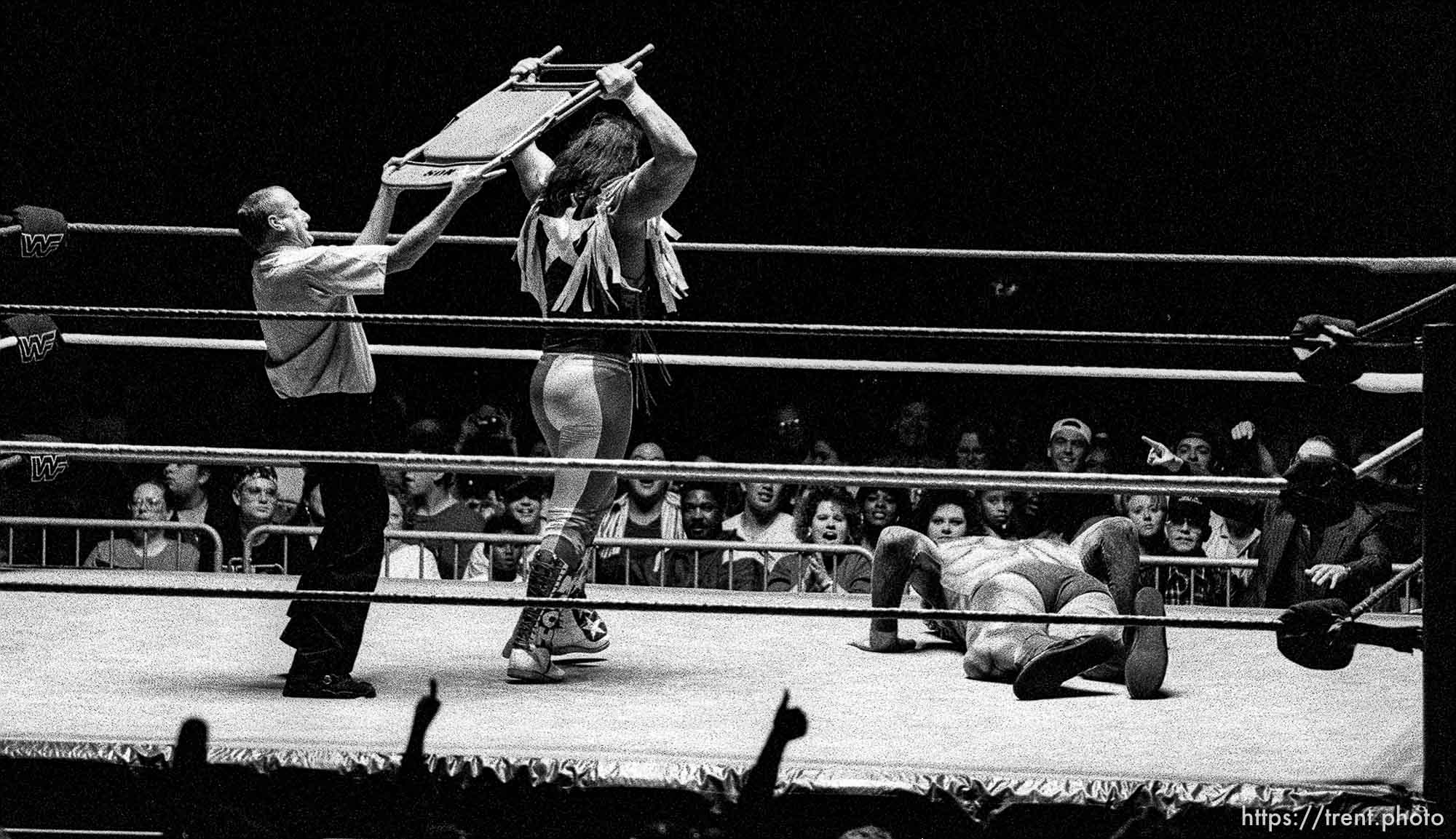 Ref stops Randy Savage from hitting El Gigante with a chair at WWF Pro-Wrestling.