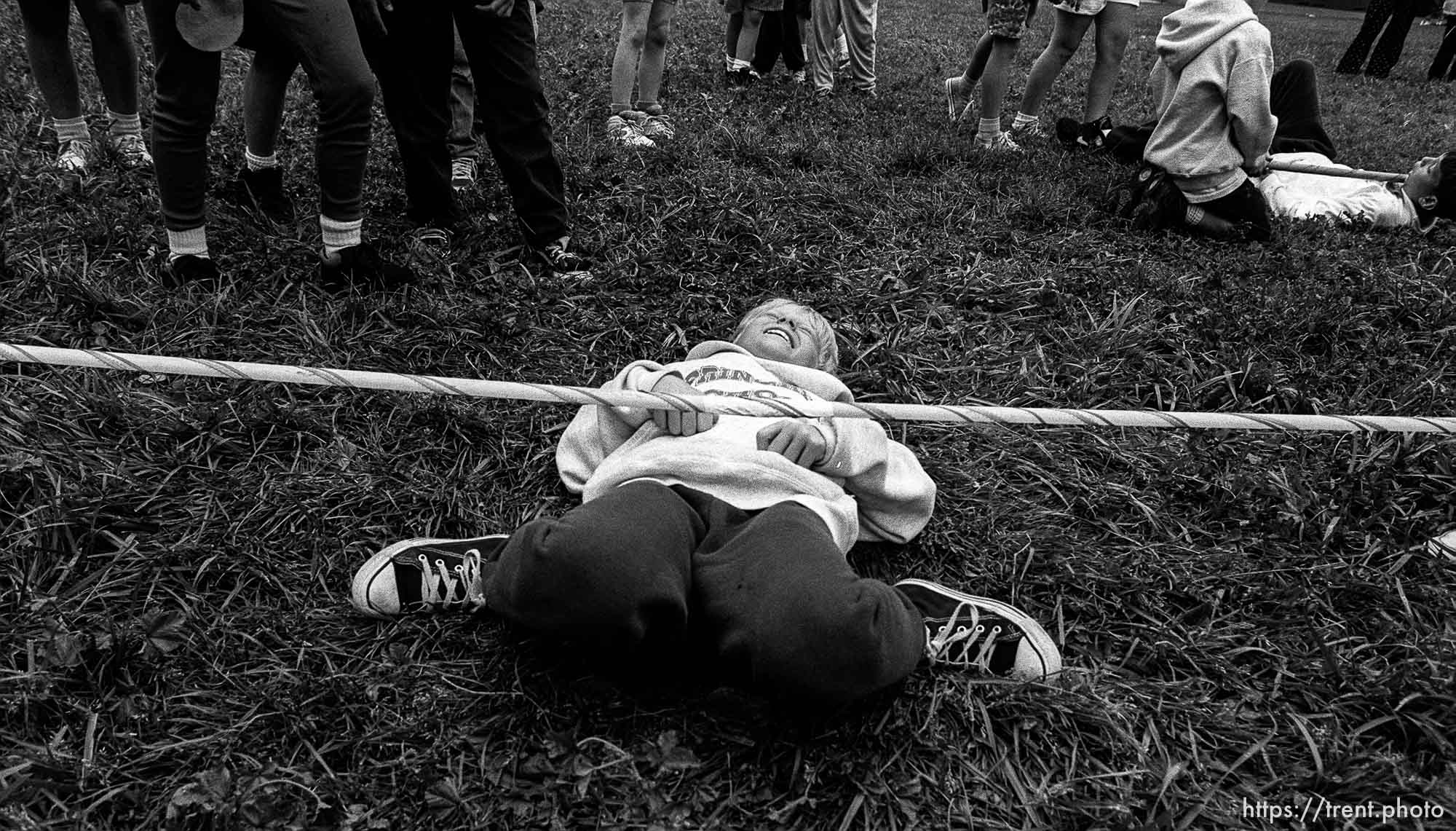 Kid laughing, doing limbo stick