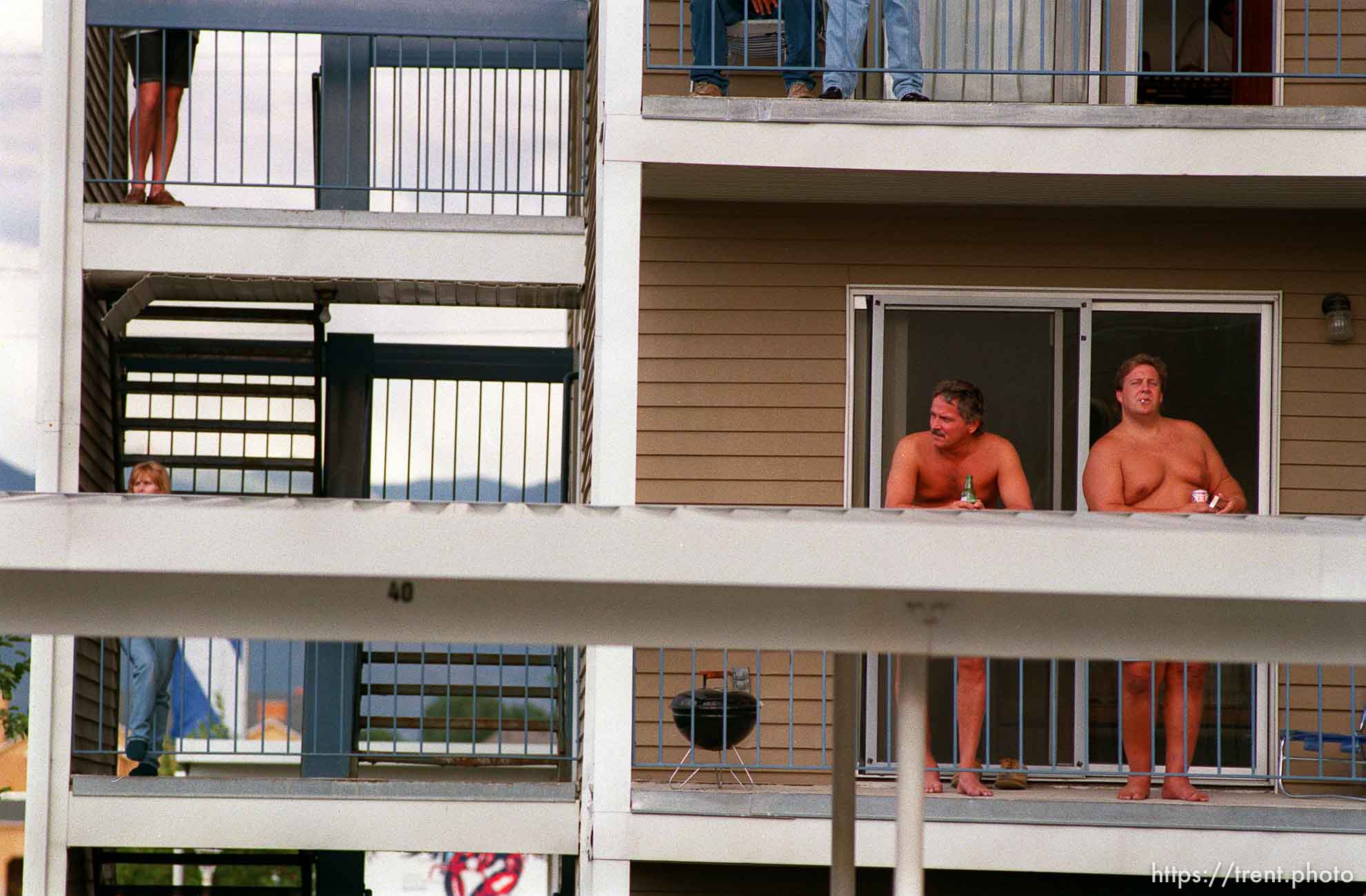 Topless men watching apartment fire