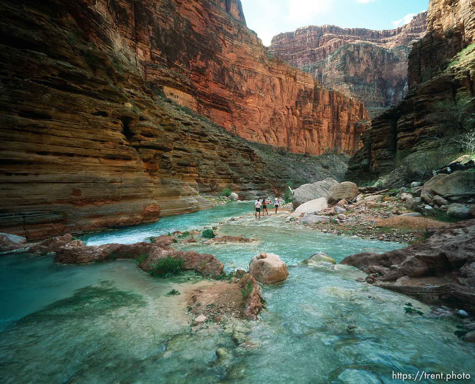 People and Blue water and rocks in Havisu Canyon. Grand Canyon flood trip.