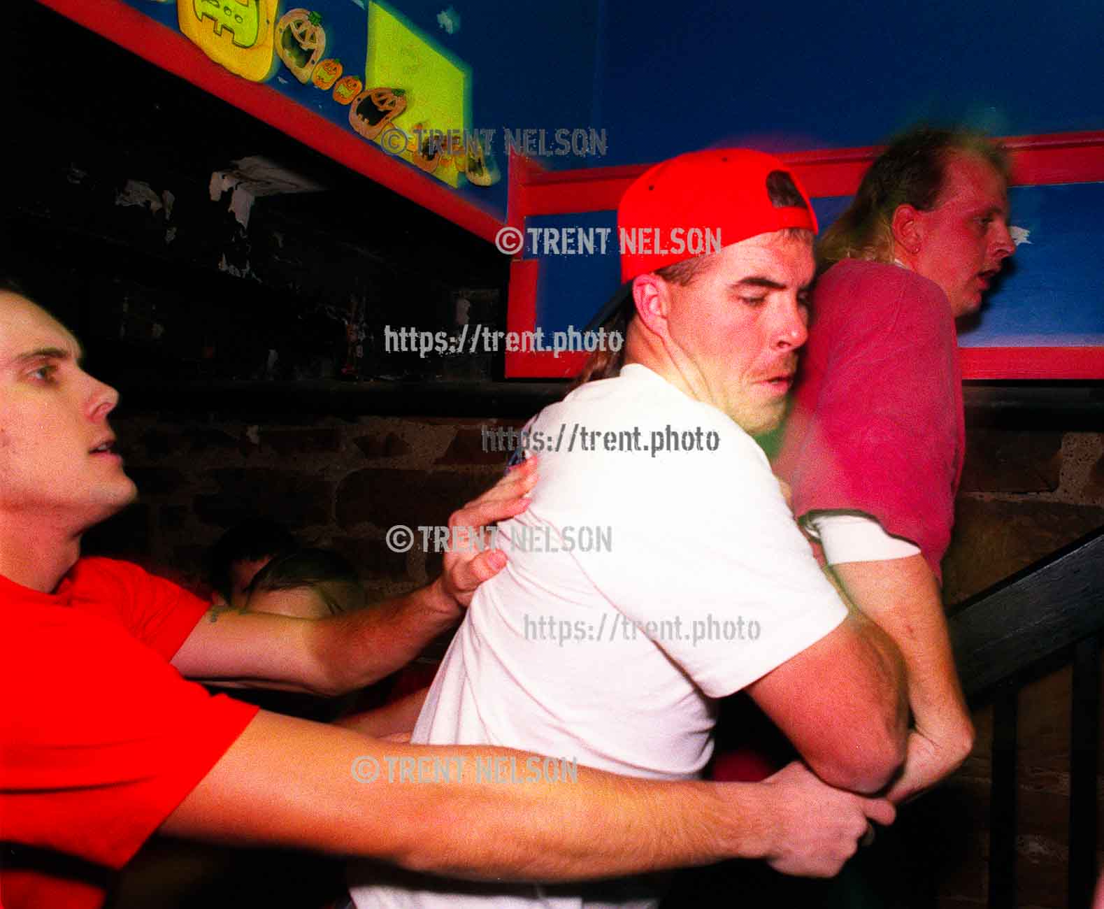 Guy being thrown out of the Godflesh show after straightedge kids kept bashing into him and he wanted to fight back. His friend in the white t-shirt is trying to keep things peaceful.