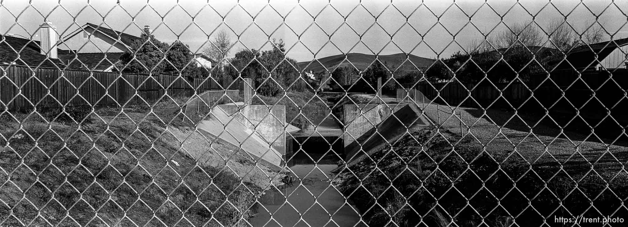 View of San Ramon Creek. through chain-link fence