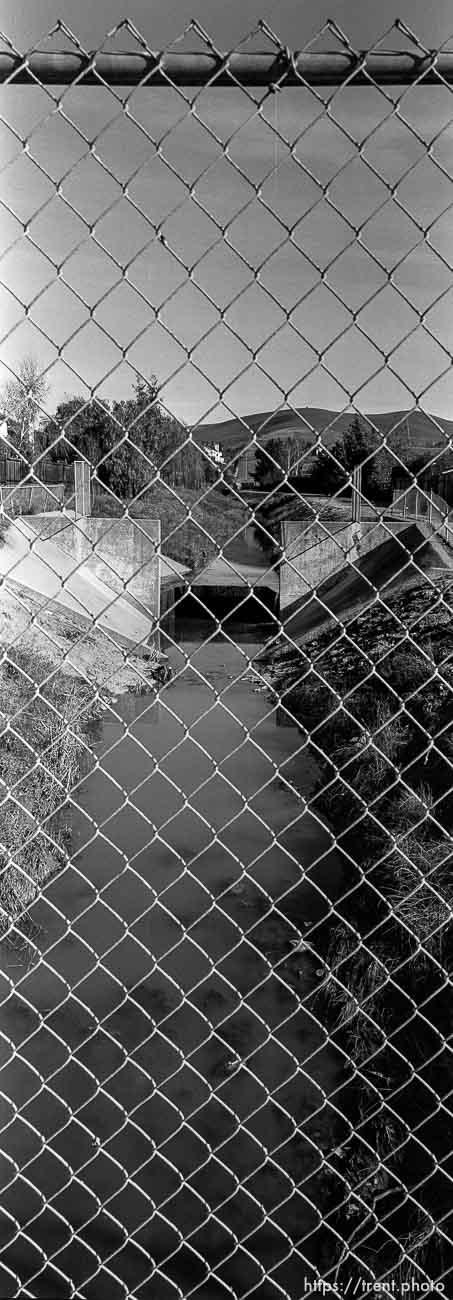 View of San Ramon Creek. through chain-link fence