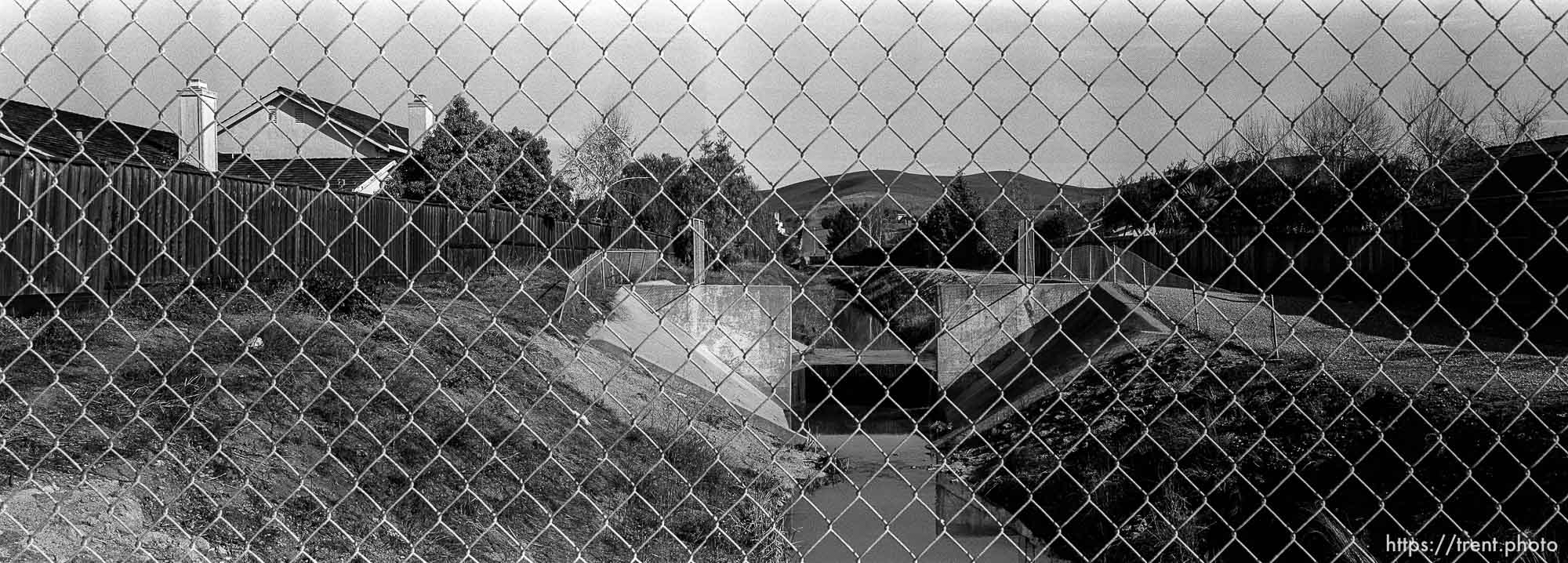 View of San Ramon Creek. through chain-link fence