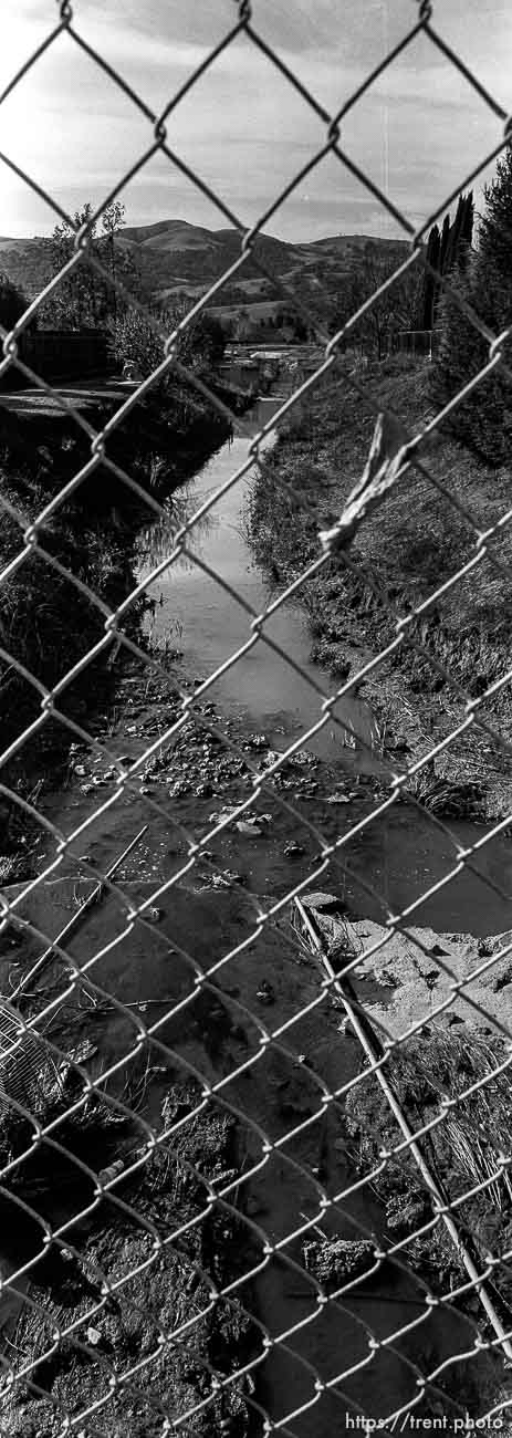 View of San Ramon Creek through chain-link fence