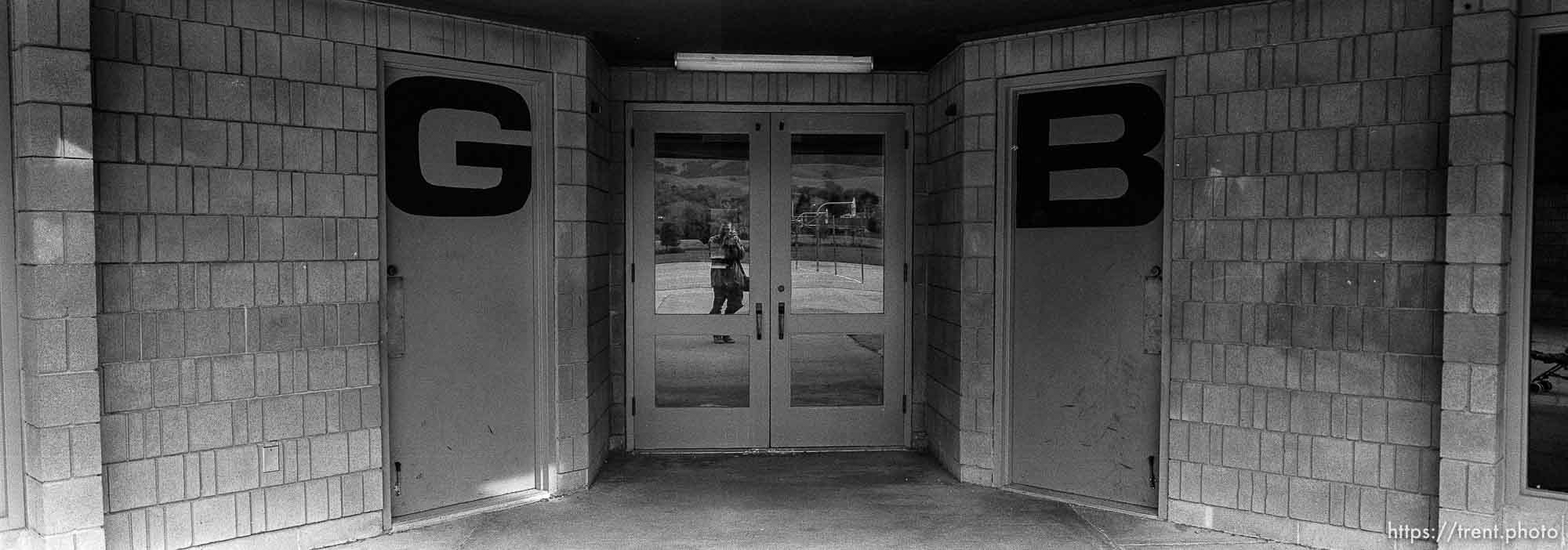 reflected in window with girls and boys bathroom dooors at Walt Disney Elementary School.