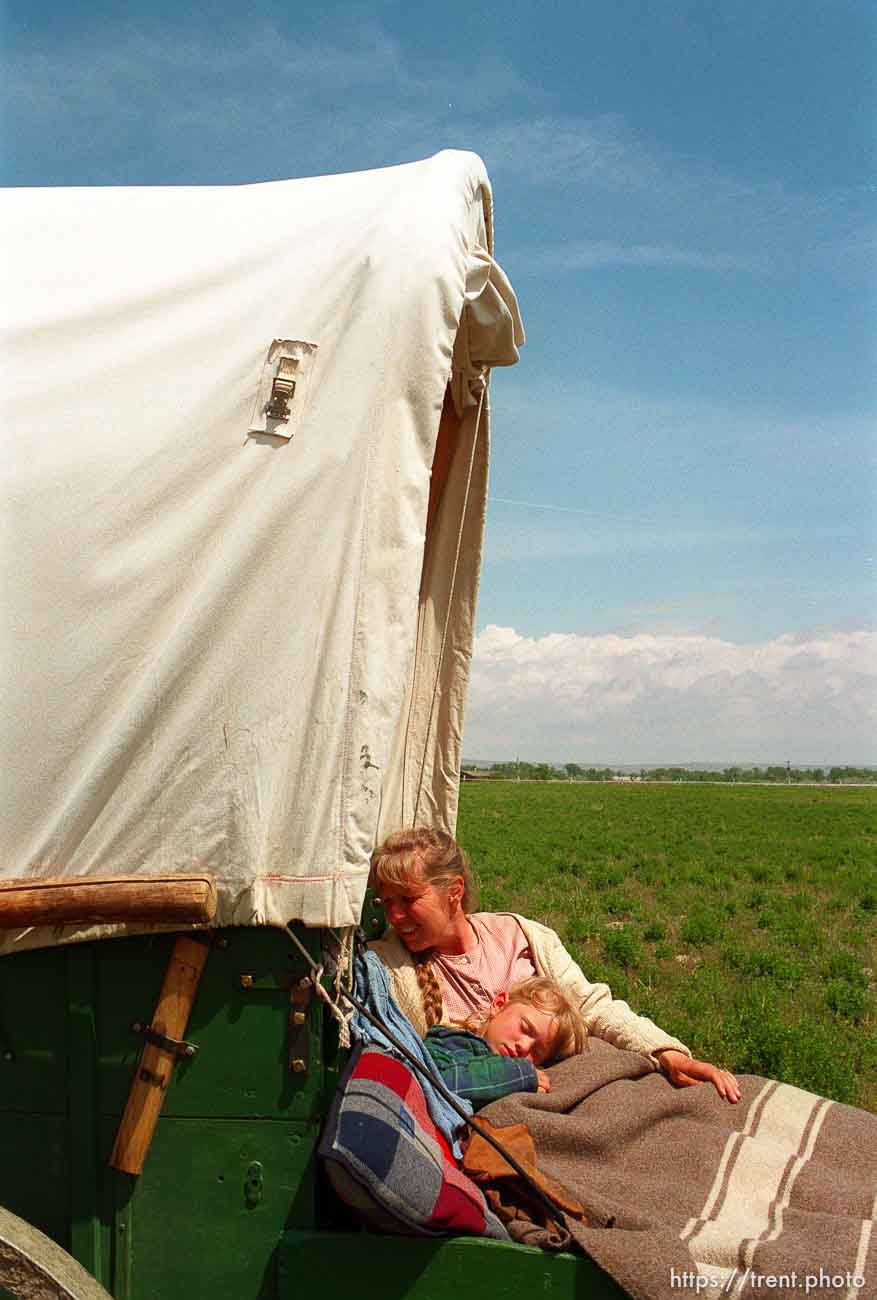 Sarah Dicken rests in her mother Shauna's arms. Sarah is sick with a 102 degree fever, as the Mormon Trail Wagon Train stops for lunch.