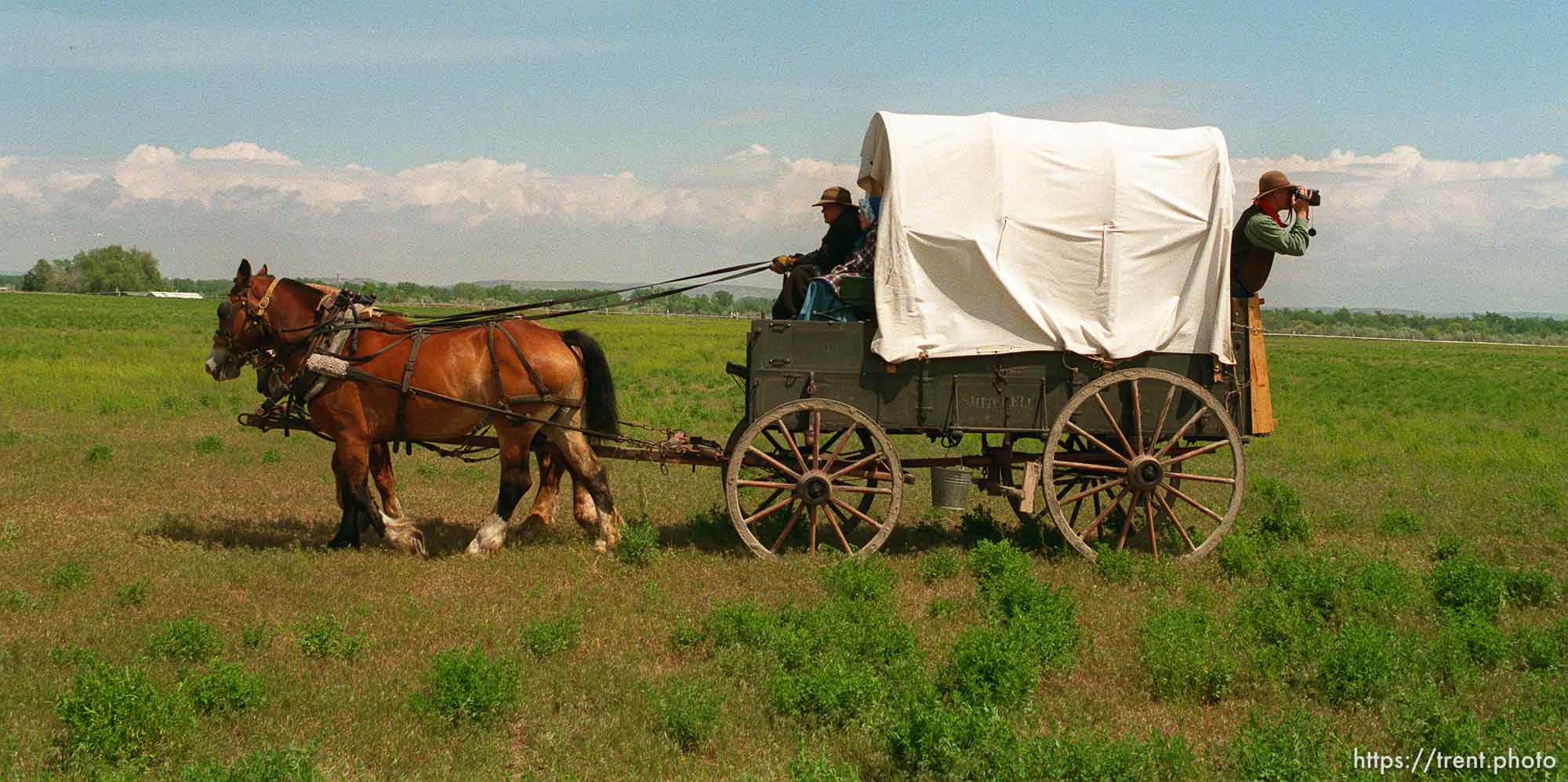 Lee Johnson, Spanish Fork, Utah, leans out the back of a wagon with a camcorder as the Mormon Trail Wagon Train stops for lunch.