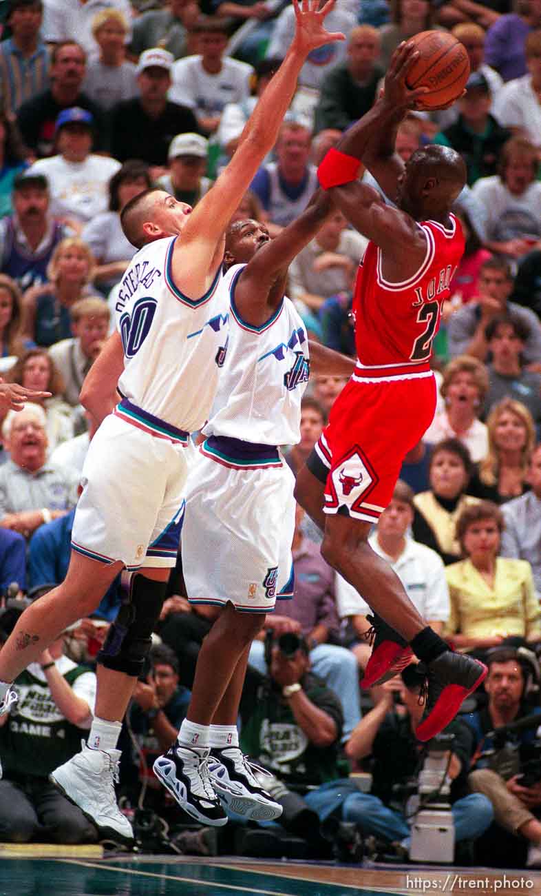 Chicago's Michael Jordan shoots a fadeaway jumper over Utah's Greg Ostertag and Bryon Russell at the NBA Finals Game four, Utah Jazz vs Chicago Bulls.