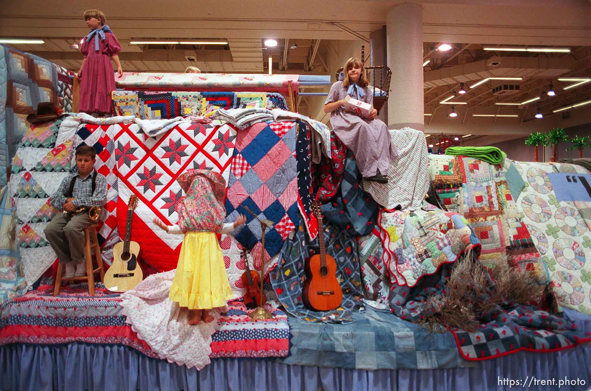 Girl with her dress over her head on the Salt Lake Grant Stake float which featured 150 quilts (1 for each year since pioneers came) at the preview of floats for the Days of '47 Parade.