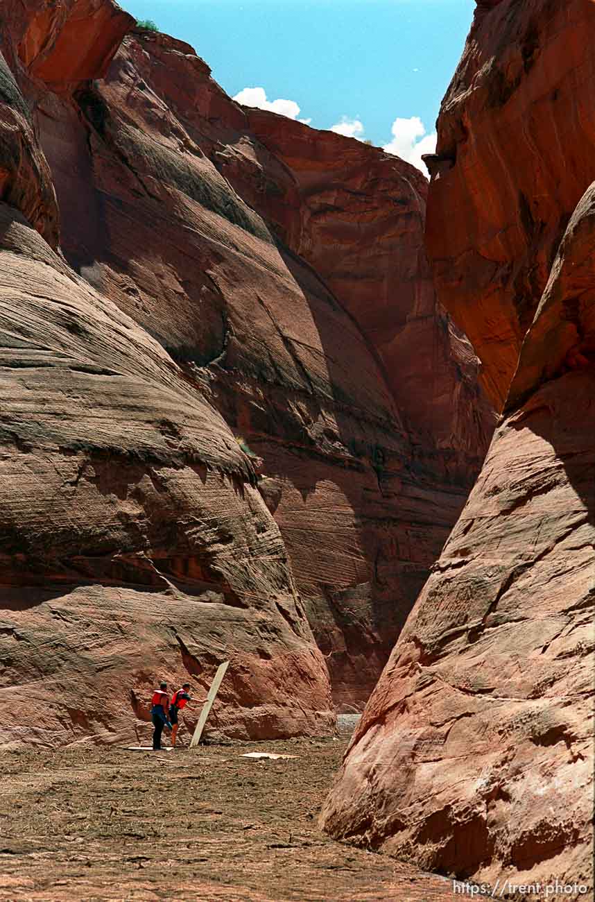 Rescue workers use plywood sheets to cross a quicksand-like debris flow in Antelope Canyon while searching for the bodies of 11 missing hikers after a flash flood.