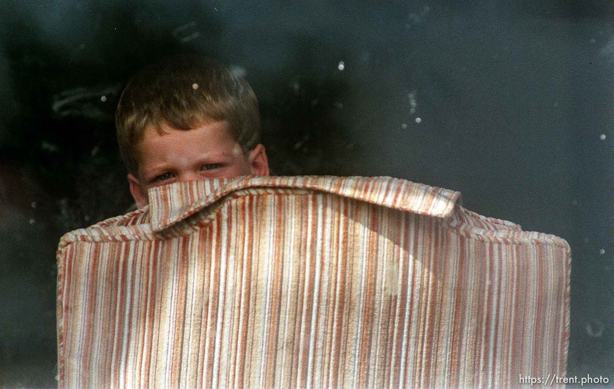 Little boy watches the media who are camped outside of his home covering a hostage situation.