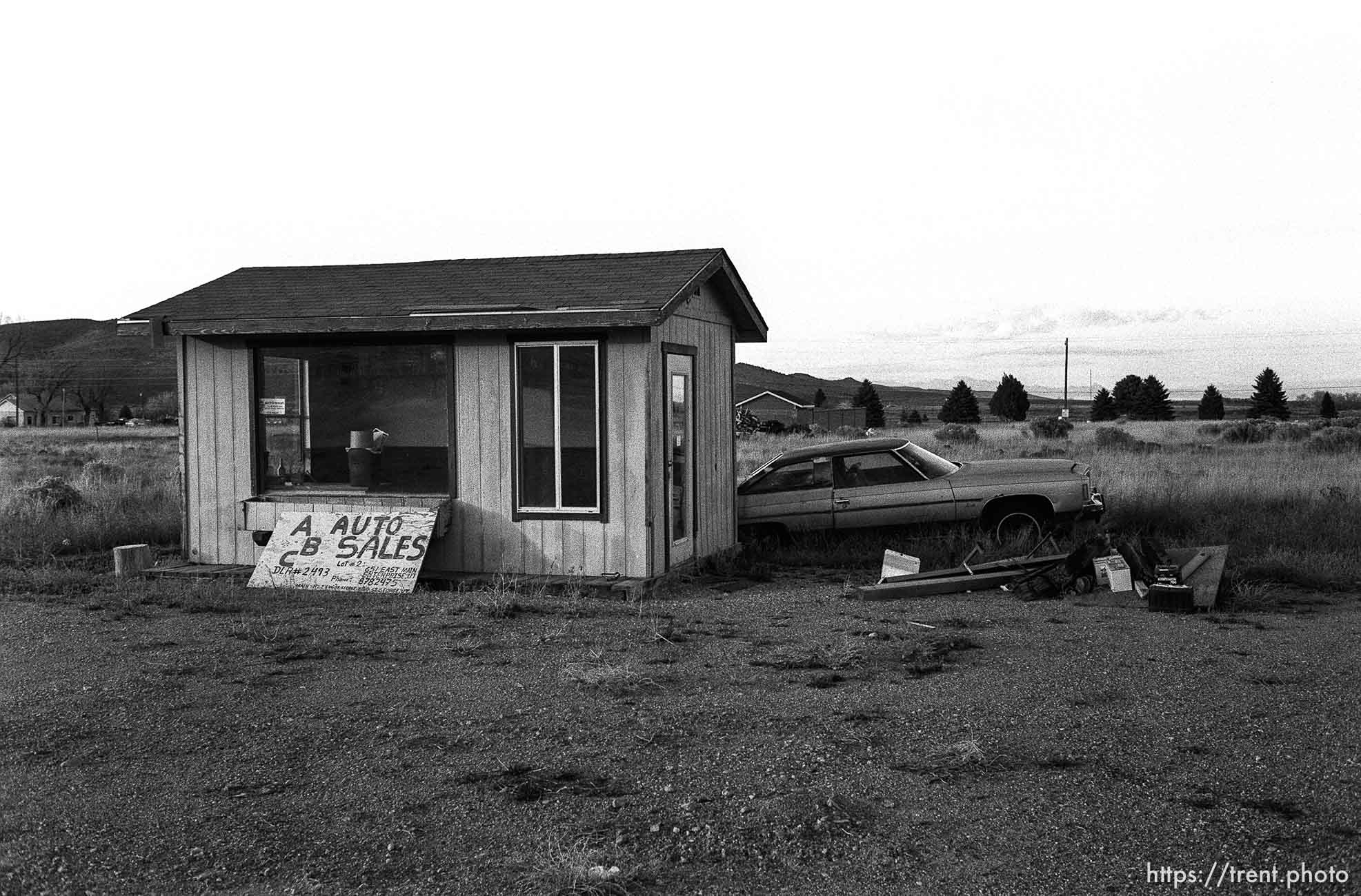 ABC Auto Sales, a deserted shack and car in empty lot.