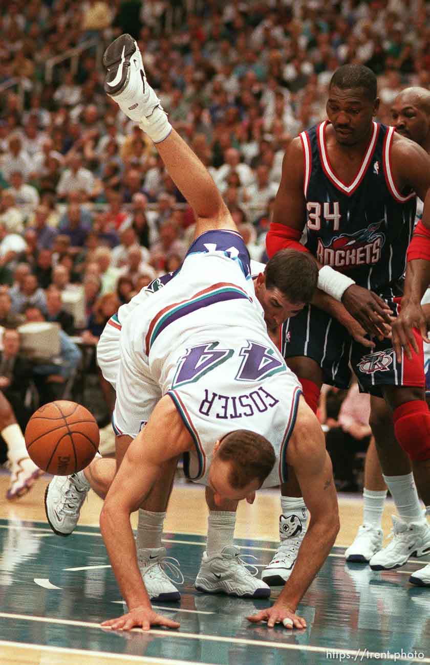 Utah's Greg Foster goes over John Stockton trying to get a loose ball at Utah Jazz vs. Houston Rockets, game 5 of the 1st round, NBA Playoffs. Jazz won. Hakeem OIajuwon in the background (#34).