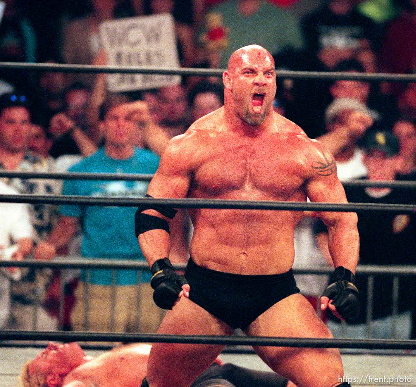 Goldberg celebrates in front of a prone Curt Hennig at WCW's Bash at the Beach.