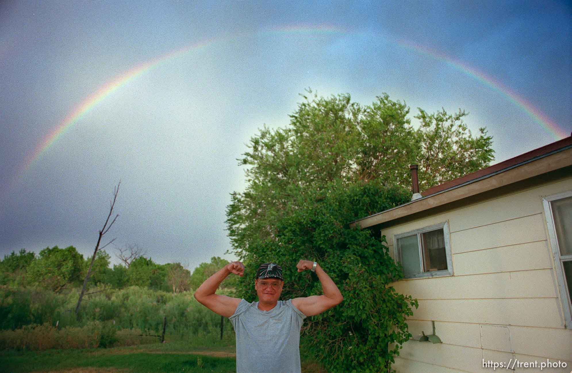 David Wopsock flexes his muscles under a rainbow.