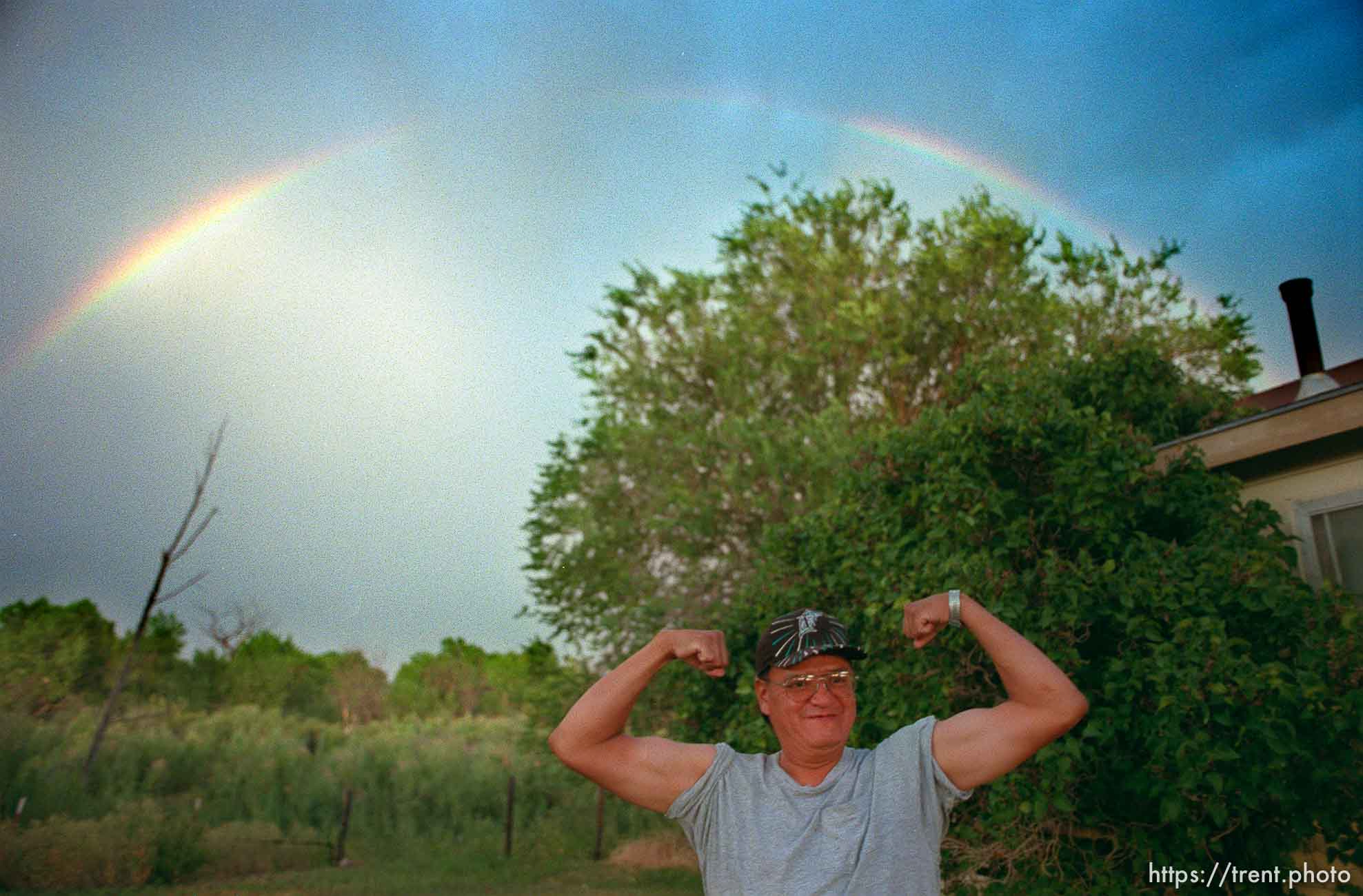 David Wopsock flexes his muscles under a rainbow.