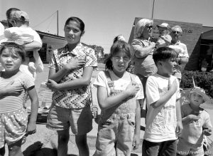 Parade watchers put their hands on their hearts as the U.S. flag passes at the 4th of July parade on Main Street.